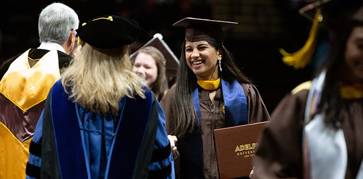 ӰƬ University graduate joyfully shaking hands during commencement