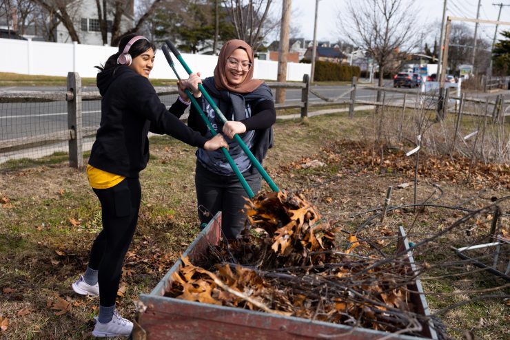 Panther Day of Service at ӰƬ - two students remove leaves for a community garden on campus.