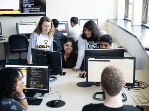 ӰƬ University computer science classroom: students learning at monitors