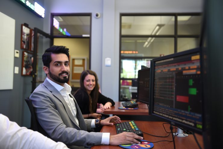 ӰƬ students using Bloomberg terminals in the Riley Trading Room