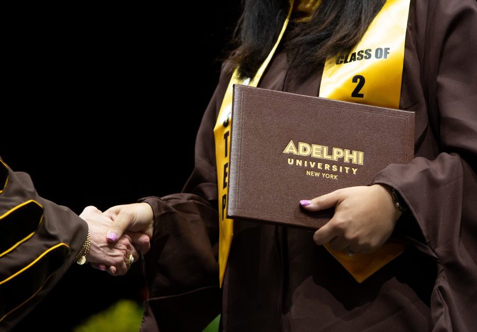 ӰƬ University Commencement - graduate shaking hands with diploma