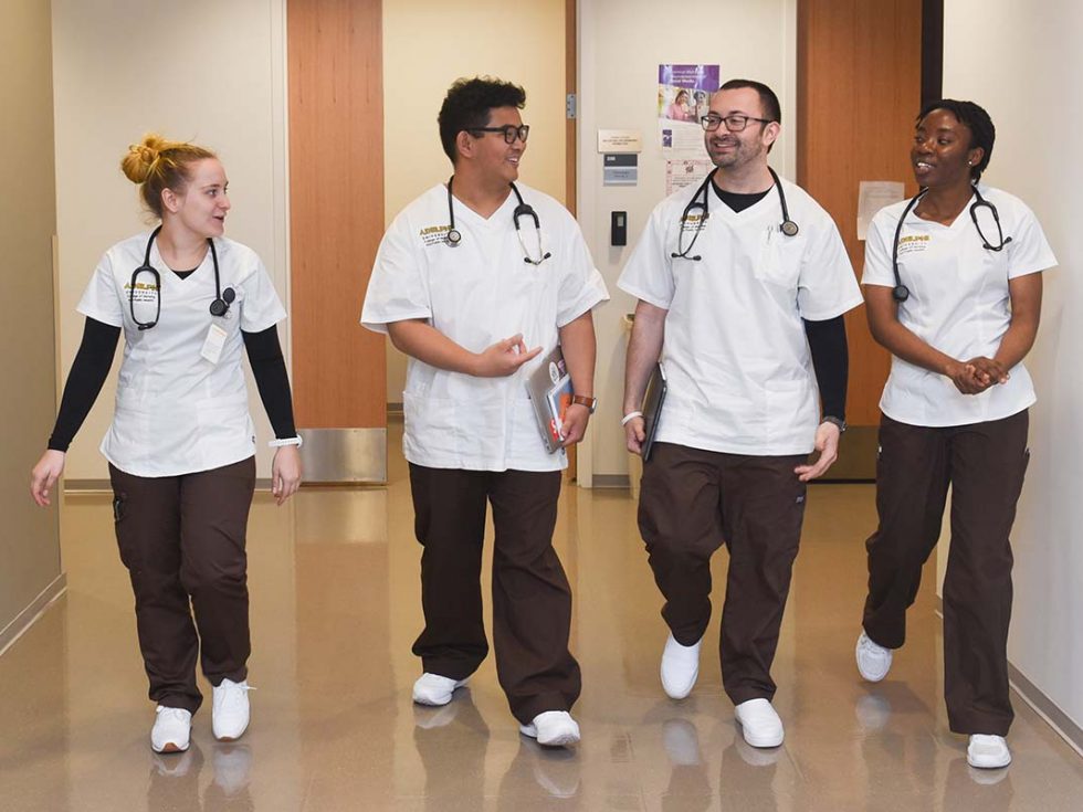 a diverse group of 成人影片 Nursing students walking down a hallway together