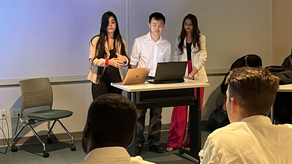 Three 成人影片 Students standing at front of classroom and presenting. 
