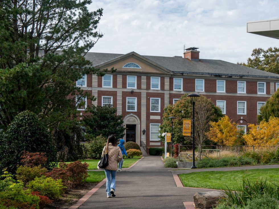 A student walks o the path toward Levermore Hall at ӰƬ University