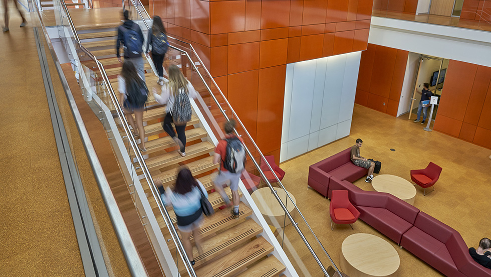 Students climb the stairs on the way to classes in the light-filled interior of ӰƬ's beautiful Nexus Building.