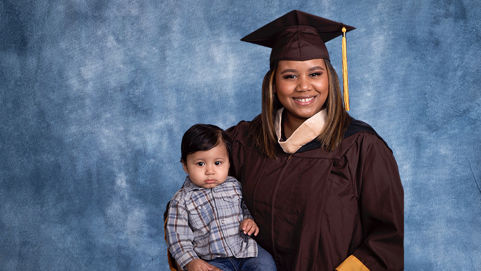 Martinez in her ӰƬ cap and gown, holding her son, Kairo.